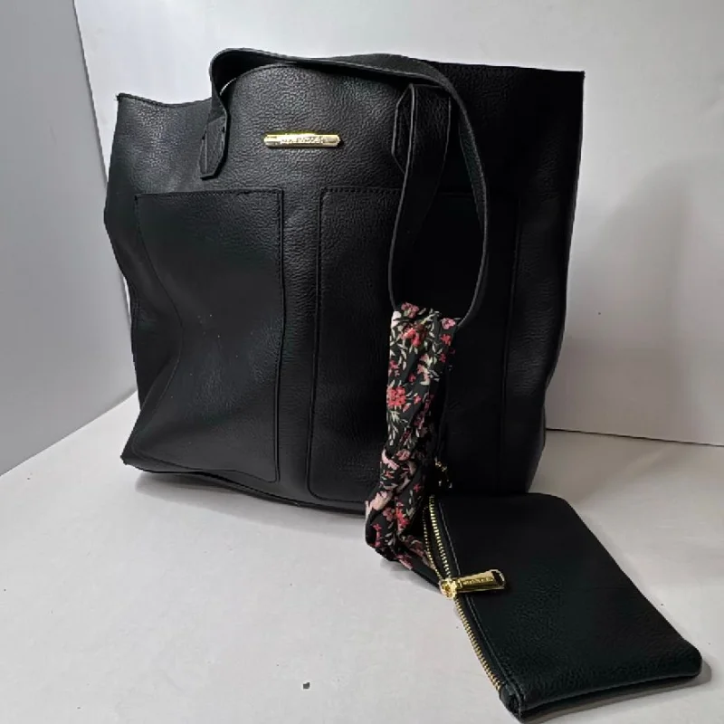 A black leather tote bag slumped on a table next to its matching pouch and a floral scarf.